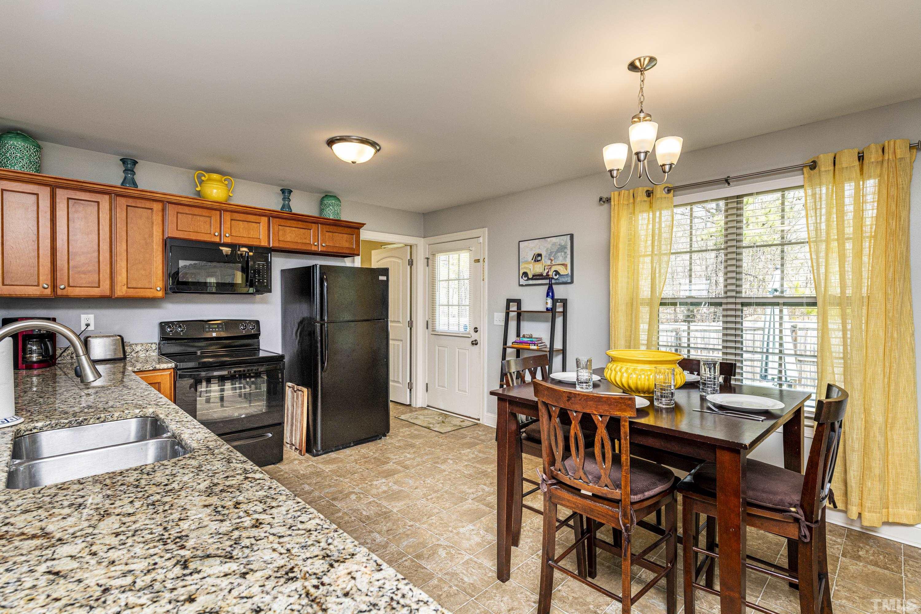 312 Wick Road Stem, NC 27581 - Photo 9 of 34 a kitchen with stainless steel appliances granite countertop a stove refrigerator and a sink