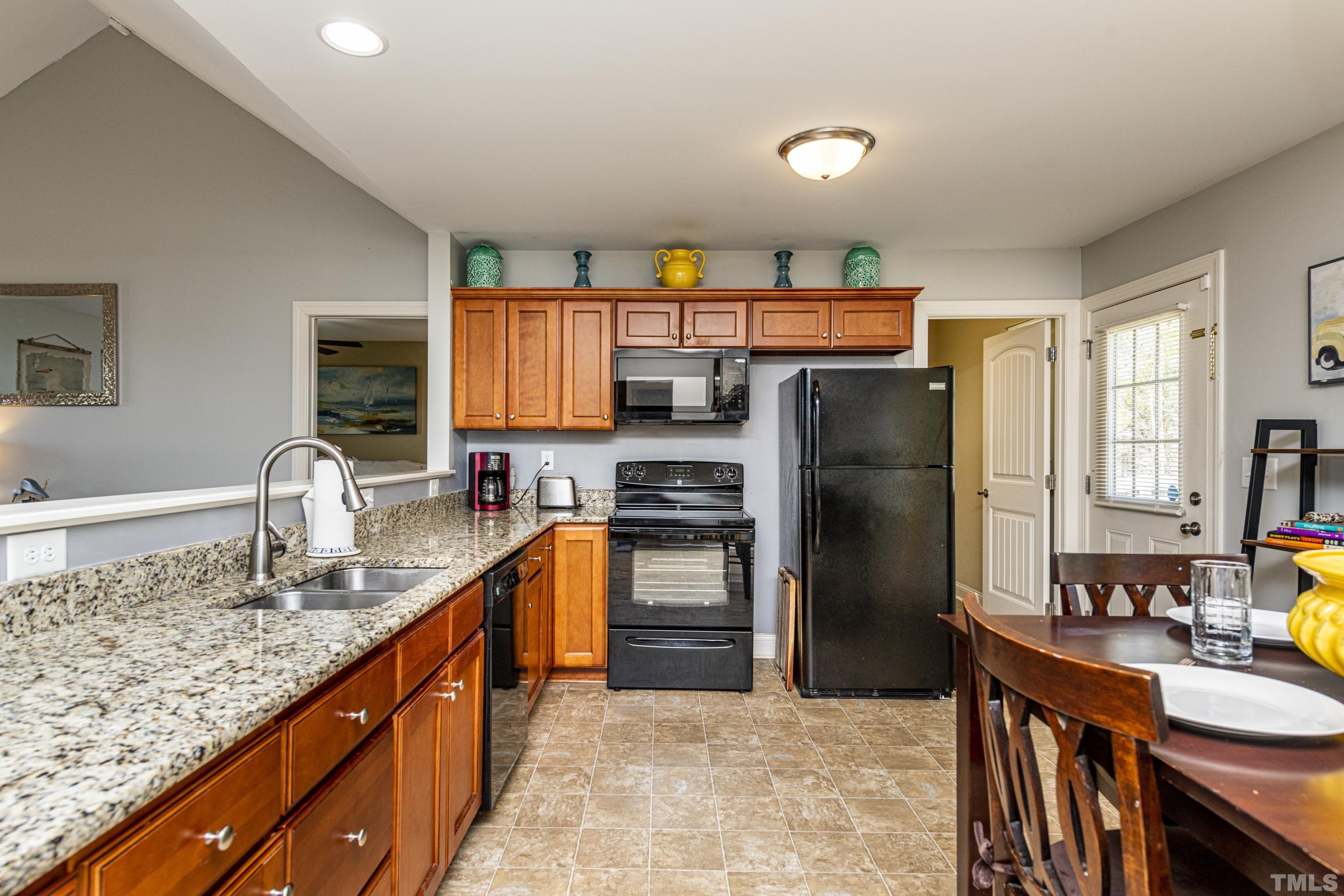 312 Wick Road Stem, NC 27581 - Photo 10 of 34 a kitchen with stainless steel appliances granite countertop a refrigerator a stove and a sink with wooden floors