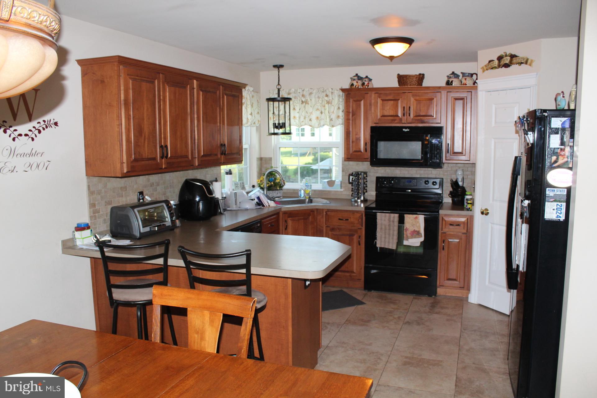 2 Jennifer Court Reading, PA 19608 - Photo 16 of 45 a kitchen with stainless steel appliances granite countertop a stove top oven a sink a dining table and chairs with wooden floor