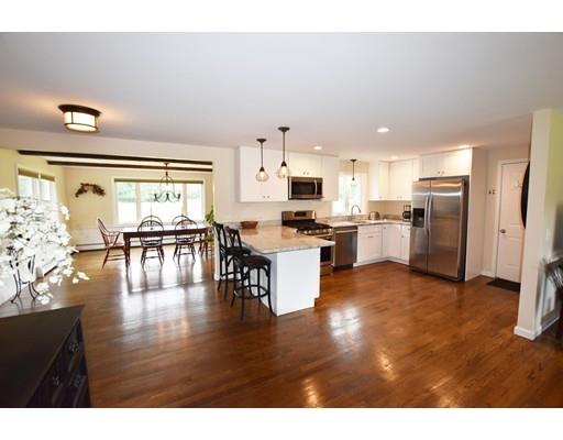 306 Bolton Road Lancaster, MA 01523 - Photo 4 of 30 a kitchen with stainless steel appliances granite countertop a refrigerator a stove top oven a sink and a dining table with wooden floor