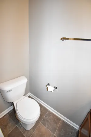 a white toilet sitting next to a white wall