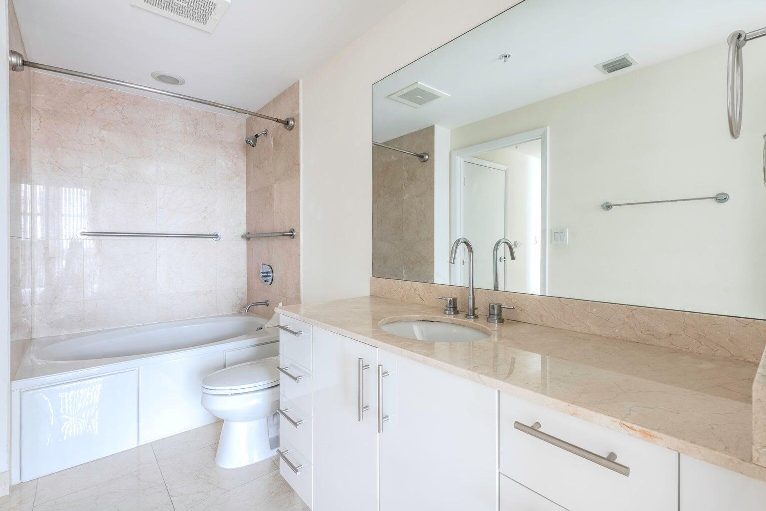 550 Okeechobee Boulevard, Unit 1718 West Palm Beach, FL 33401 - Photo 9 of 13 a bathroom with a granite countertop sink toilet and shower