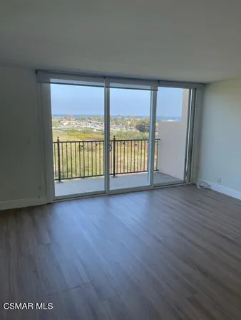 an empty room with wooden floor and glass door