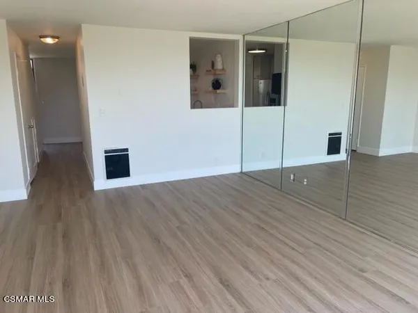 a view of a hallway with wooden floor