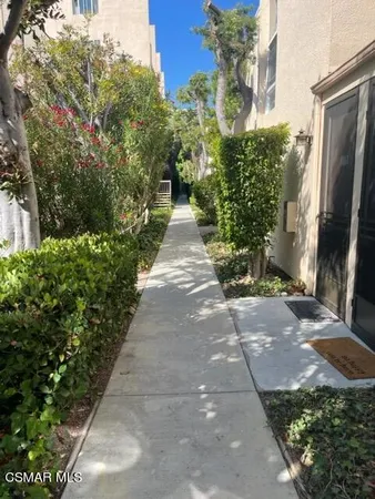 a view of a pathway with flower plants