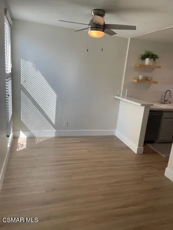 a view of a room with wooden floor and ceiling fan