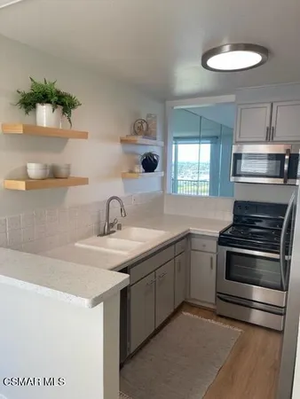 a kitchen with stainless steel appliances granite countertop a sink and a stove
