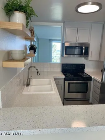 a kitchen with granite countertop a stove and a sink