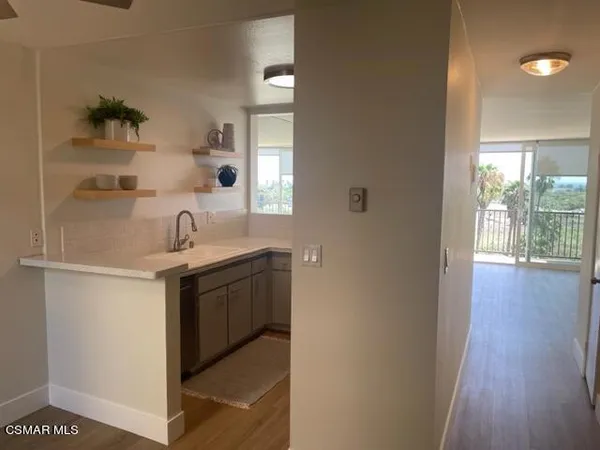 a kitchen with a sink and wooden floor