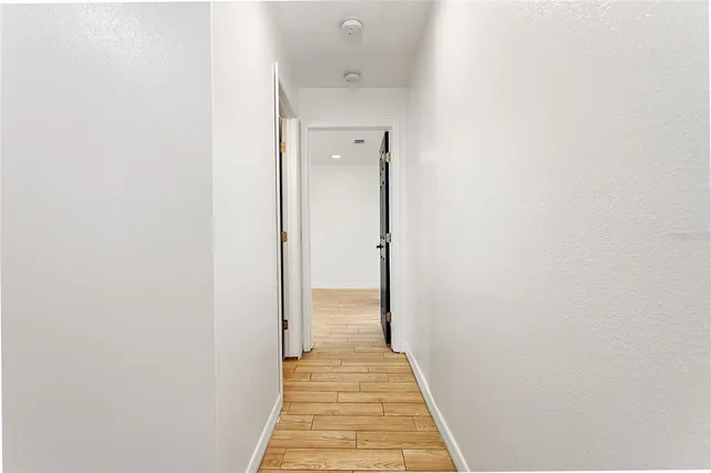 a view of a hallway with wooden floor