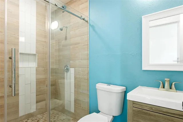 a bathroom with a sink a toilet and shower