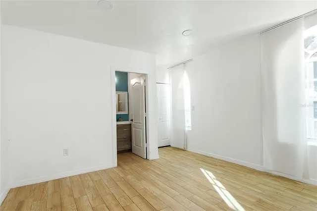 an empty room with wooden floor and closet