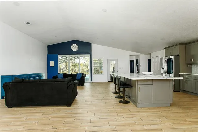 a living room with furniture a large window and kitchen view