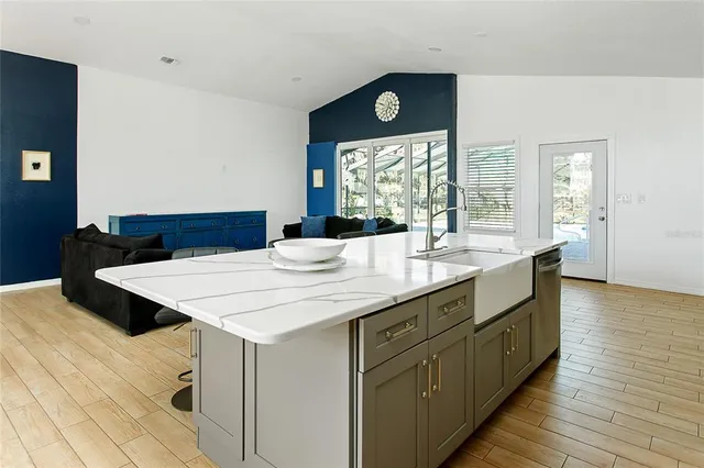 a kitchen with a sink and wooden floor
