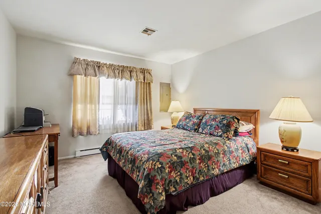 a bedroom with a bed and a flat tv screen on a dresser