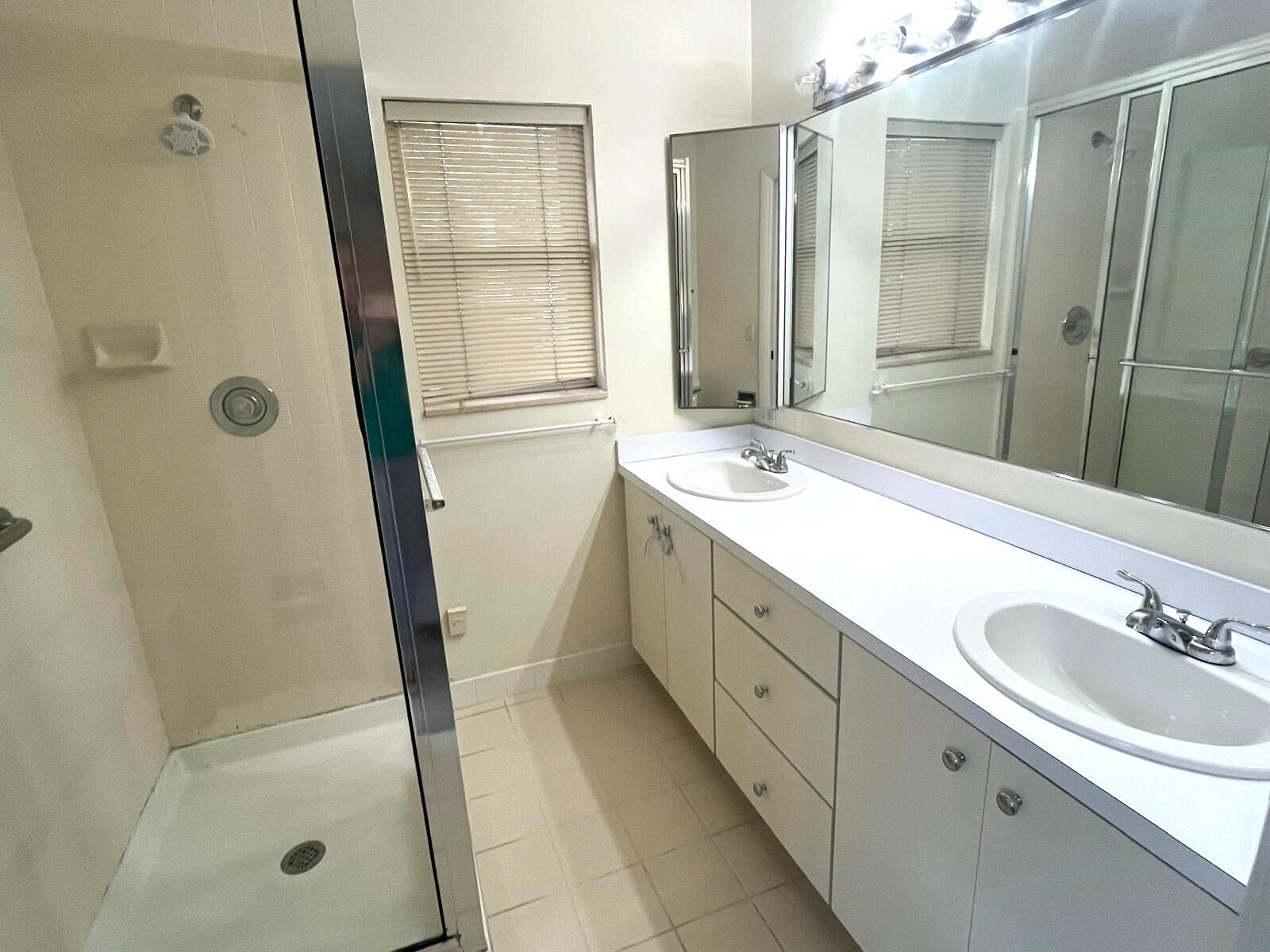 7 Amherst Court, Unit A Royal Palm Beach, FL 33411 - Photo 25 of 45 a bathroom with a double vanity sink mirror and shower