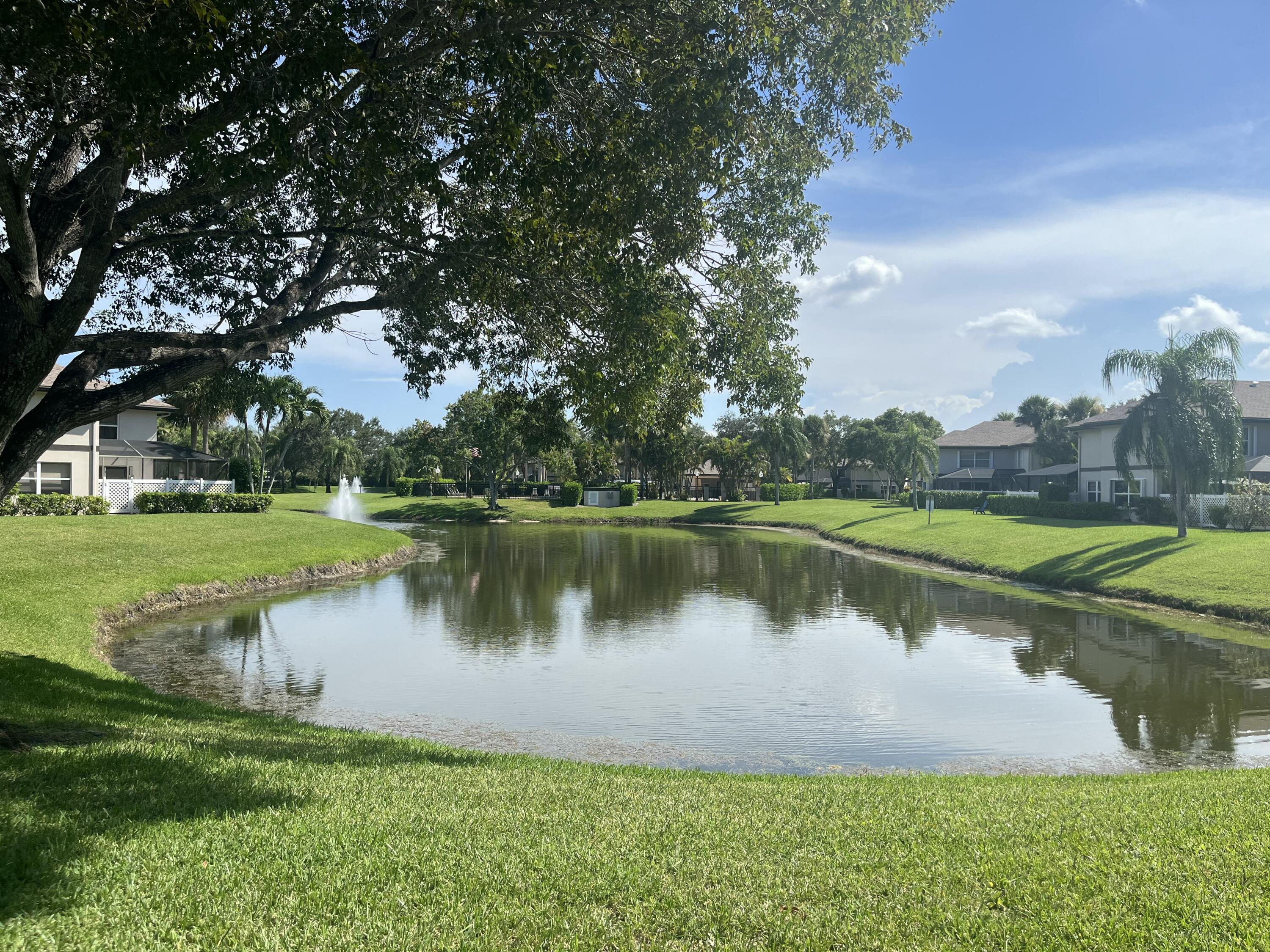7 Amherst Court, Unit A Royal Palm Beach, FL 33411 - Photo 5 of 45 a view of a lake with a house in the background