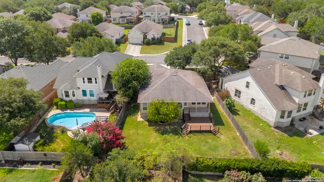 an aerial view of residential houses with outdoor space and swimming pool