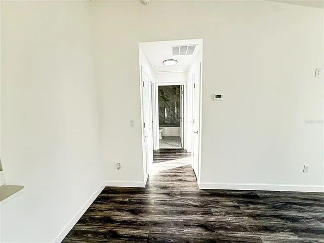 a view of a room with wooden floor and white wall