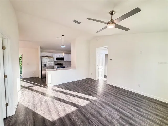 a view of a kitchen with wooden floor and a ceiling fan