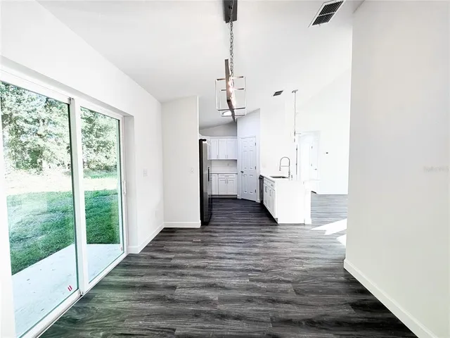 a view of empty room with wooden floor and windows