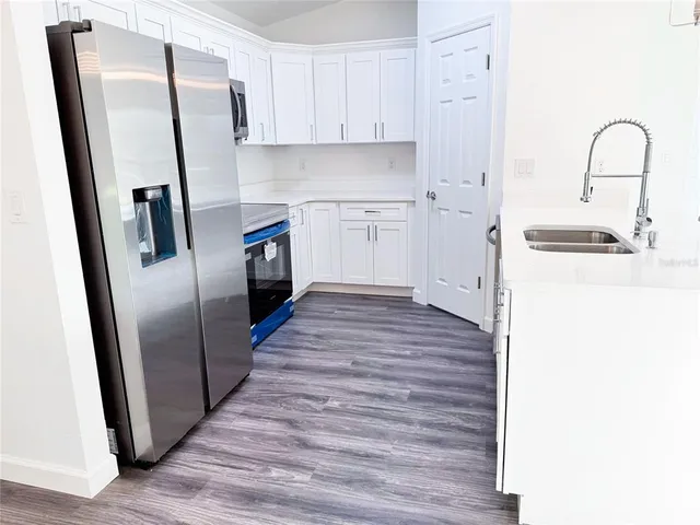a kitchen with a refrigerator sink and cabinets