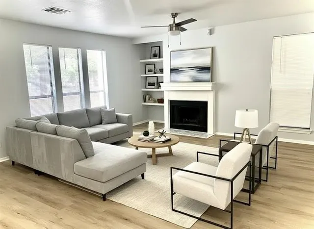 a living room with furniture fireplace and a large window