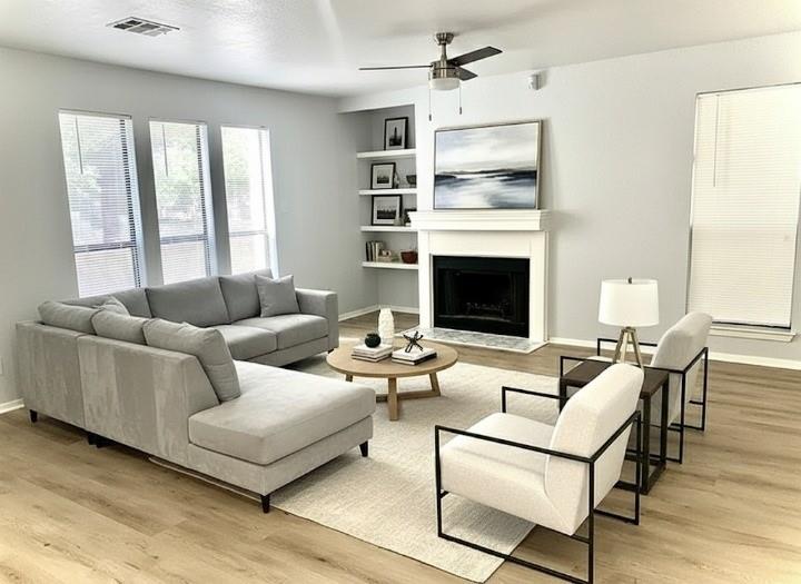 a living room with furniture fireplace and a large window
