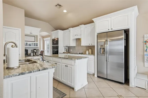 a kitchen with stainless steel appliances granite countertop a refrigerator and a sink