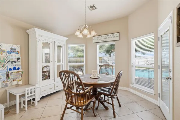 a dining room with furniture a chandelier and window