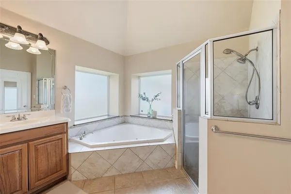 a bathroom with a tub a sink and mirror