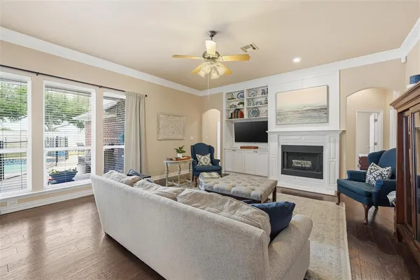 a living room with furniture a fireplace and a large window