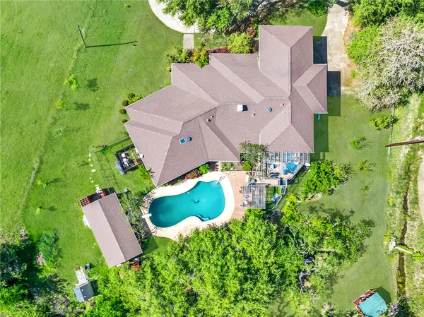 an aerial view of a house with a garden and trees