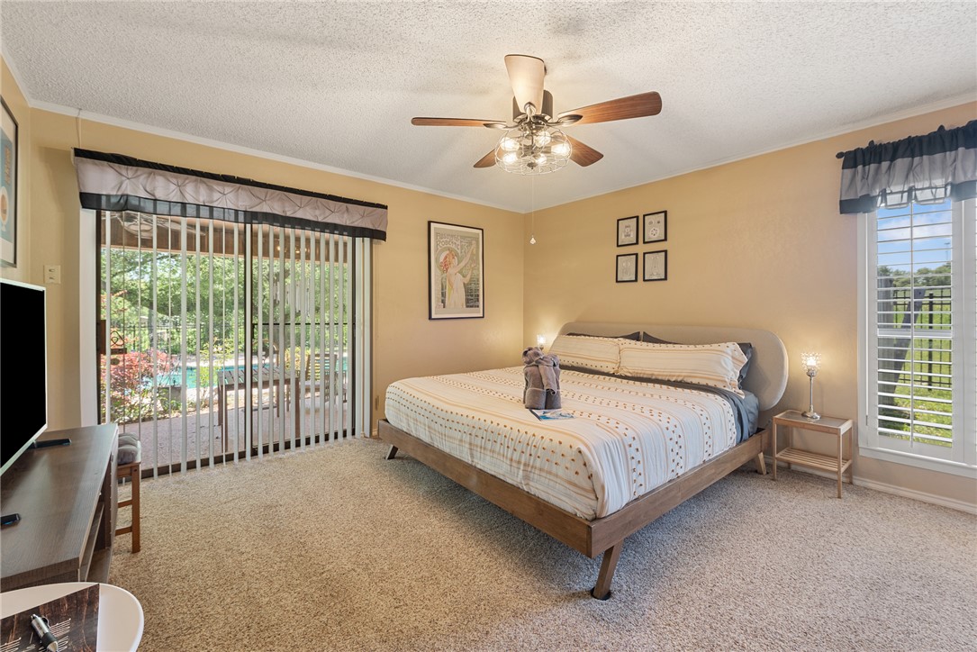 1309 Rock Dam Road Marlin, TX 76661 - Photo 12 of 50 Bedroom with access to exterior, a textured ceiling, and carpet floors