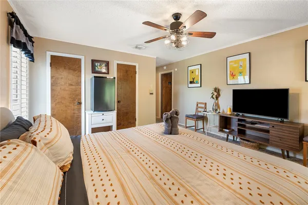 a bedroom with a bed and a flat screen tv
