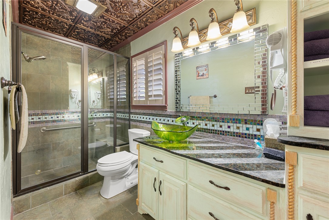 1309 Rock Dam Road Marlin, TX 76661 - Photo 16 of 50 Bathroom with toilet, a shower stall, vanity, and decorative backsplash