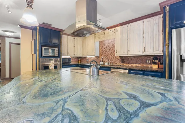 a kitchen with stainless steel appliances granite countertop a sink a counter space and cabinets