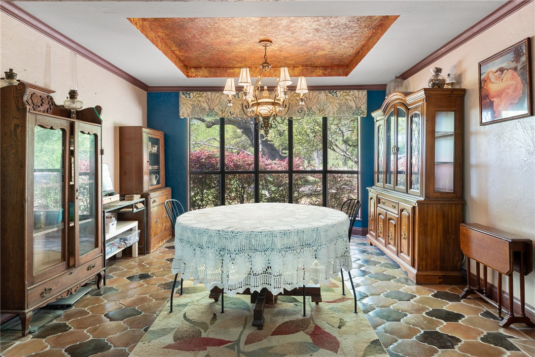 1309 Rock Dam Road Marlin, TX 76661 - Photo 23 of 50 Dining space with stone floors, an inviting chandelier, and a raised ceiling