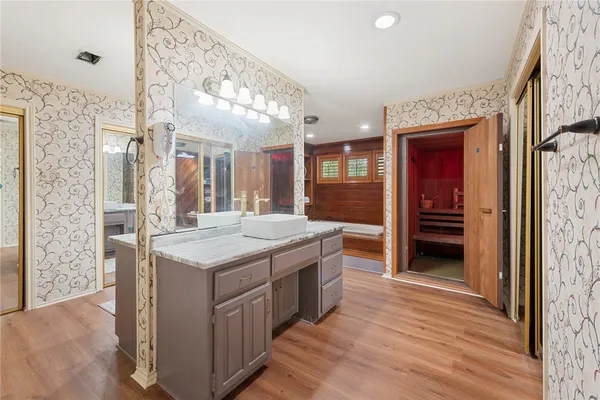 a bathroom with a granite countertop sink and a large mirror