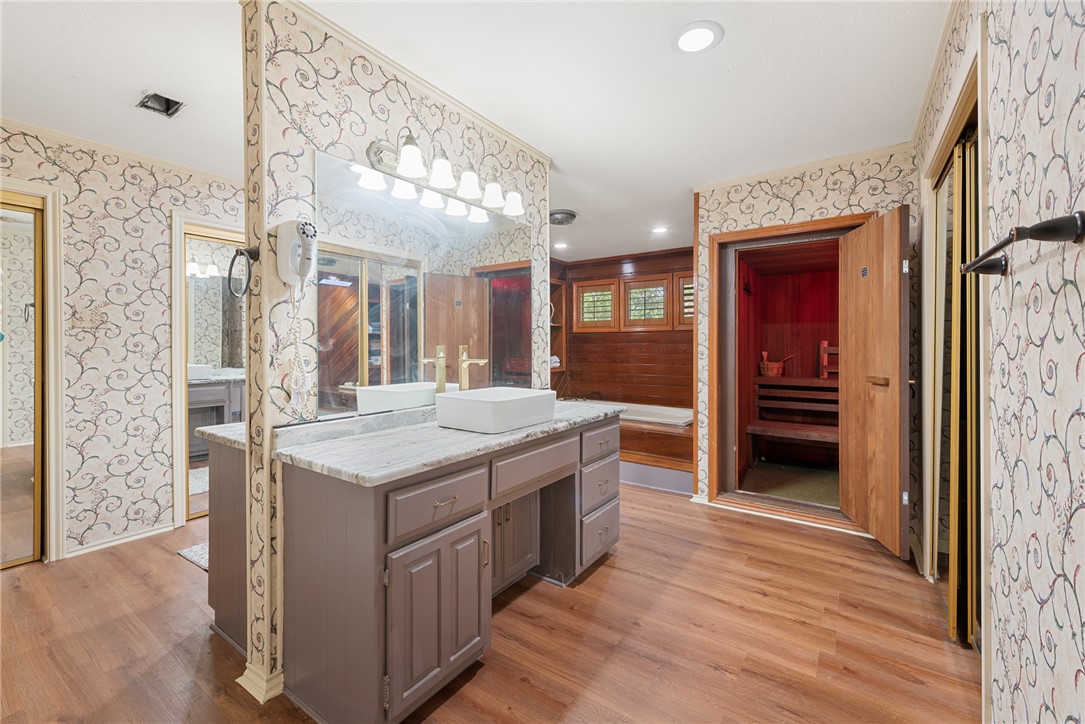 1309 Rock Dam Road Marlin, TX 76661 - Photo 25 of 50 Full bath with ornamental molding, vanity, wood finished floors, and wallpapered walls