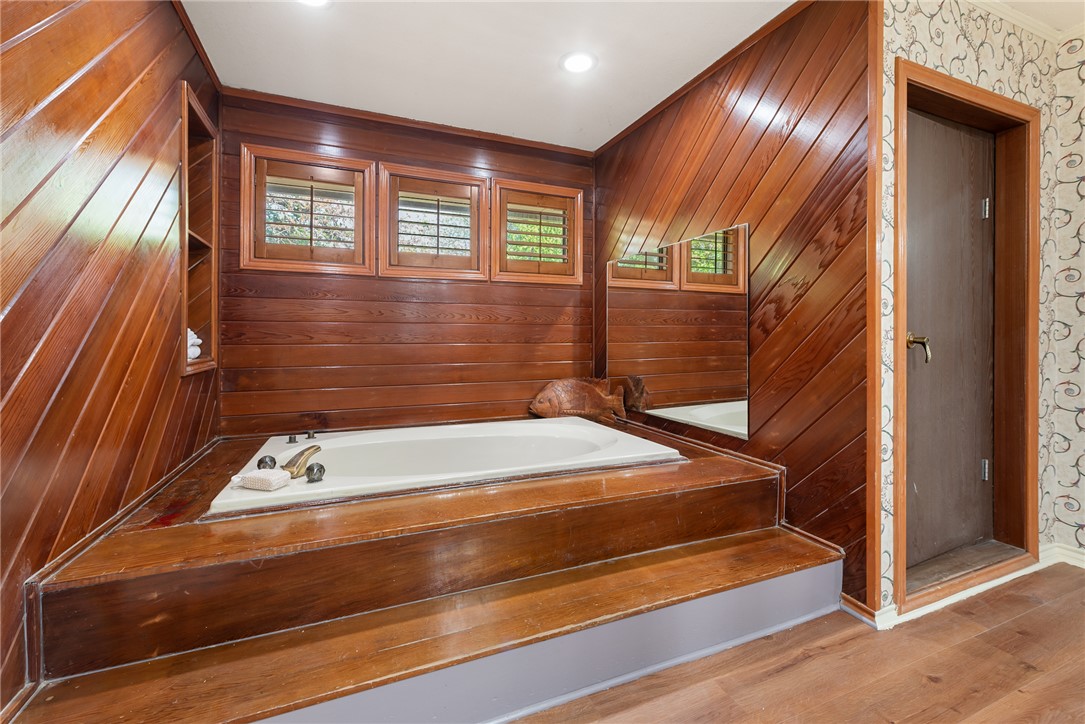 1309 Rock Dam Road Marlin, TX 76661 - Photo 28 of 50 Full bath featuring wooden walls, wood finished floors, and a garden tub