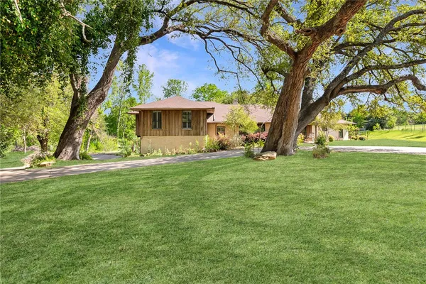 a view of backyard of house with green space