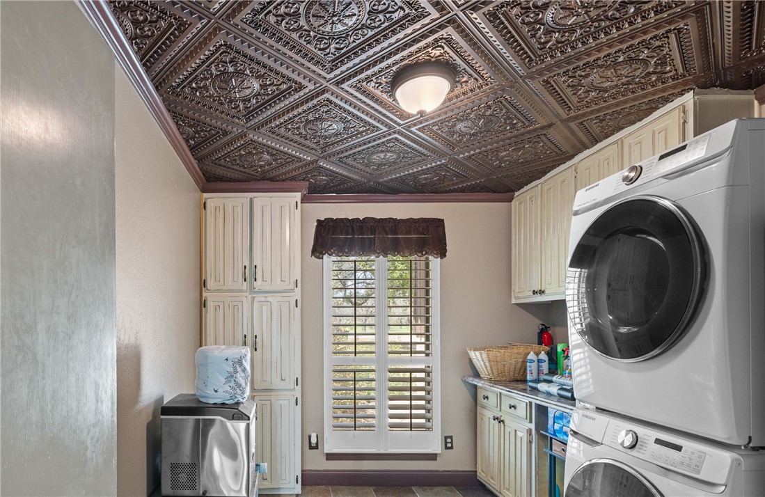 1309 Rock Dam Road Marlin, TX 76661 - Photo 42 of 50 Laundry area featuring cabinet space, an ornate ceiling, and stacked washing maching and dryer