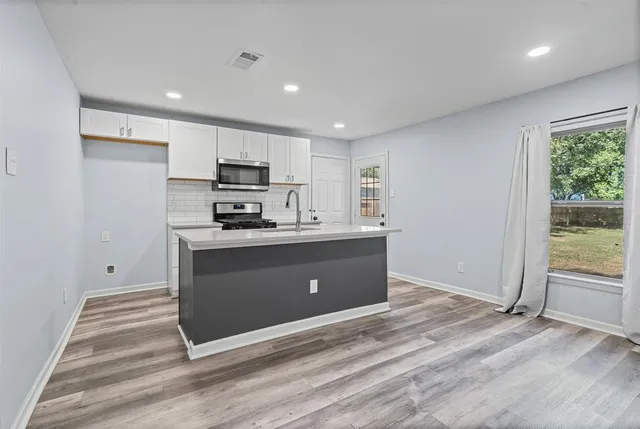 a kitchen with stainless steel appliances granite countertop a stove a sink and a refrigerator