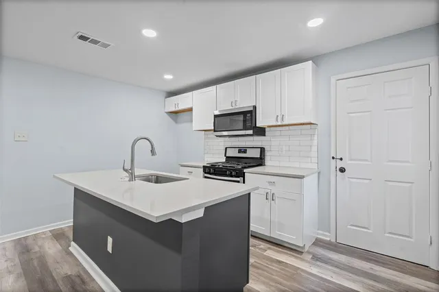 a kitchen with a sink a stove and cabinets