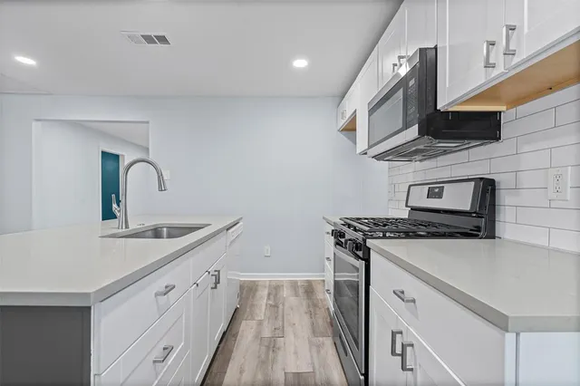 a kitchen with stainless steel appliances granite countertop a sink stove and refrigerator