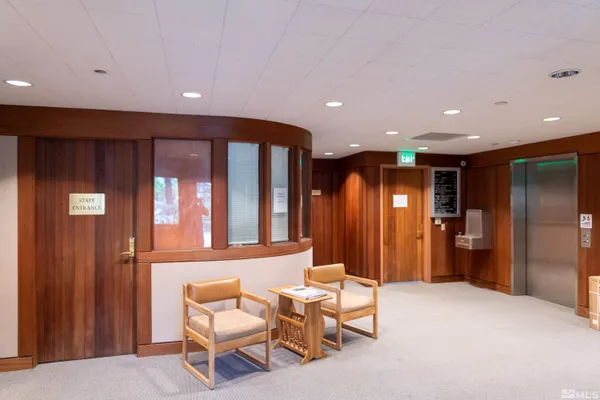 a view of a hallway with furniture and a window