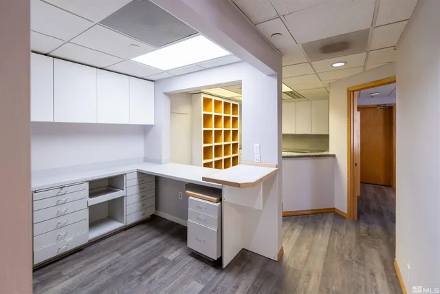 a kitchen with granite countertop wooden floors and white stainless steel appliances