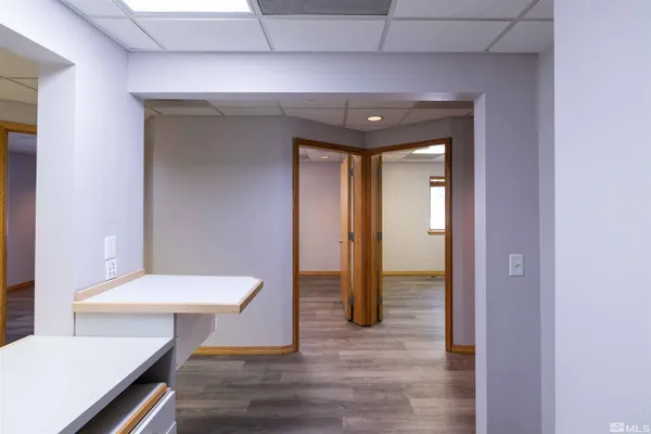 a view of a hallway that has a table and a chair