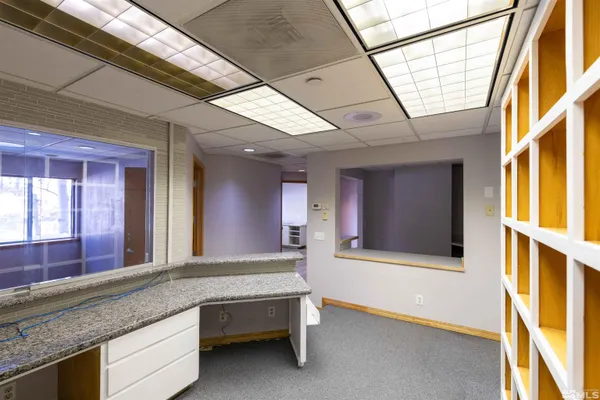 a spacious bathroom with a granite countertop sink and a large mirror next to a window